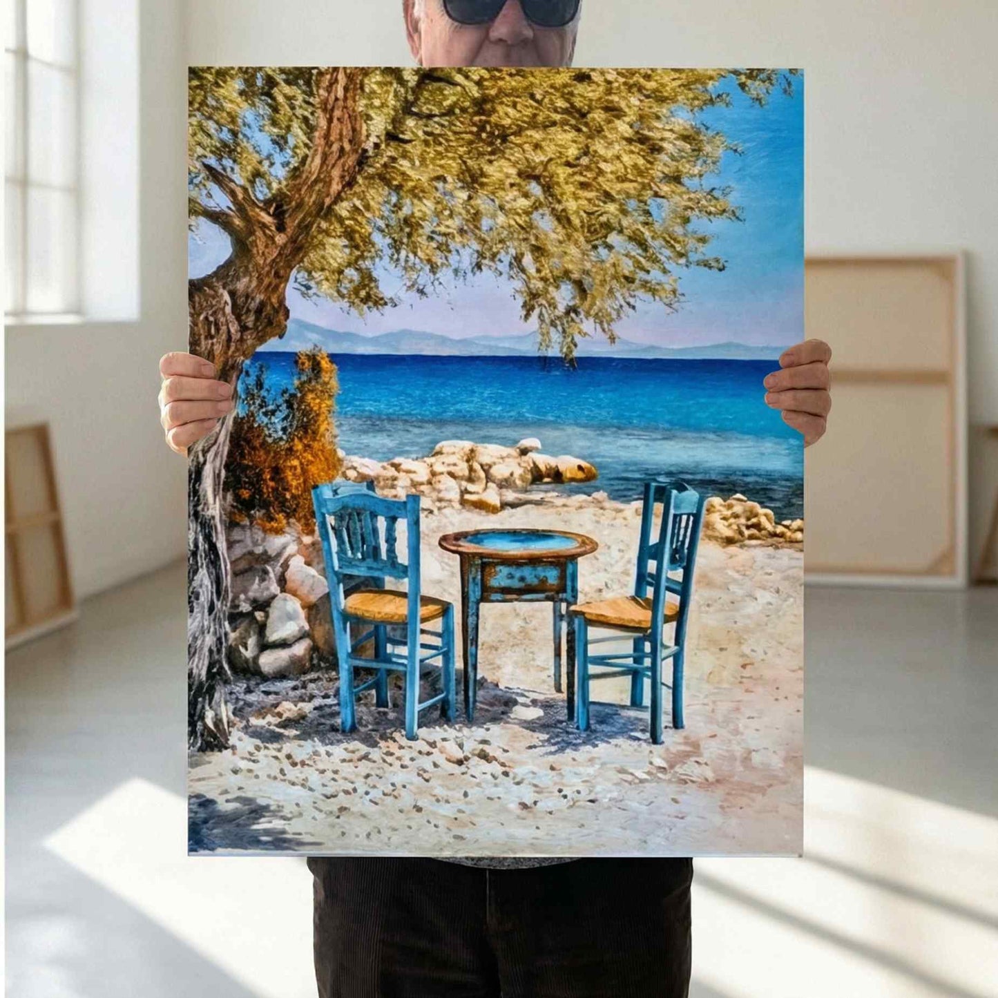 Lienzo paisaje costero al oleo con mesa y sillas azules frente al mar